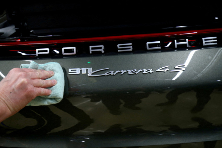 An employee of German car manufacturer Porsche fixes a Porsche 911 Carrera 4S label at the Porsche factory in Stuttgart-Zuffenhausen, Germany