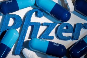 A 3D printed Pfizer logo is placed near medicines from the same manufacturer in this illustration