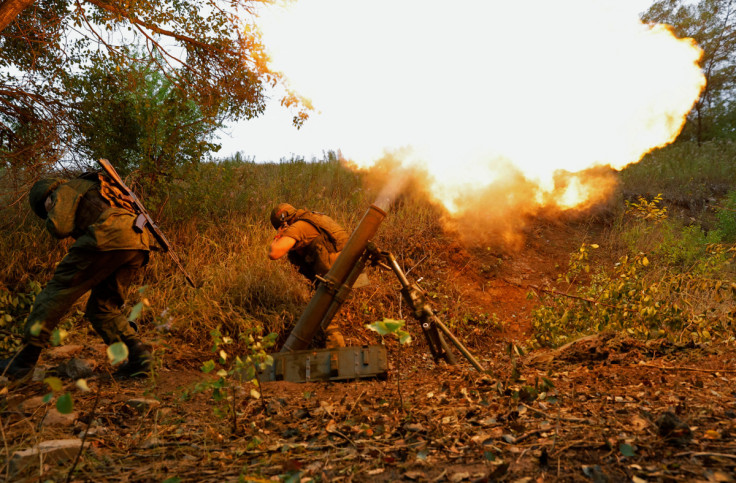 Service members of pro-Russian troops fire a mortar outside Donetsk