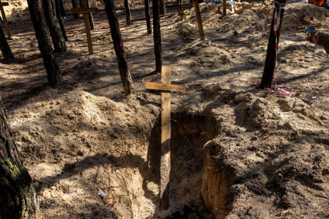 A cross is seen at a forest grave site during an exhumation in Izium