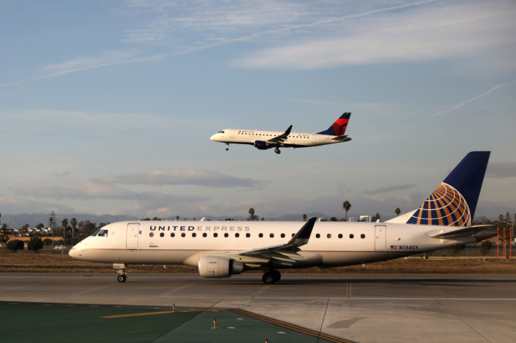 A Delta Connection plane lands as a United Express plane waits to take off at LAX airport in Los Angeles