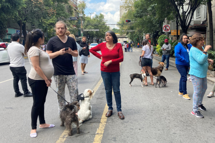 People stand in the street during a quake alarm in Mexico City