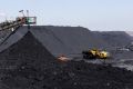 A truck drives past a conveyor pouring coal produced at Canyon Coal's Khanye colliery near Bronkhorstspruit, South Africa