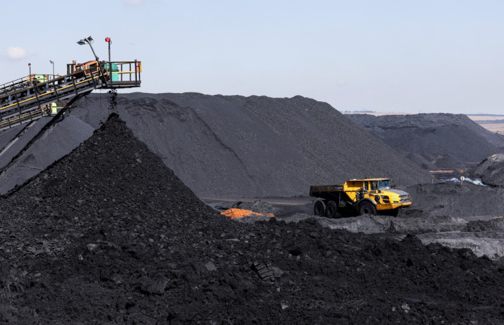 A truck drives past a conveyor pouring coal produced at Canyon Coal's Khanye colliery near Bronkhorstspruit, South Africa