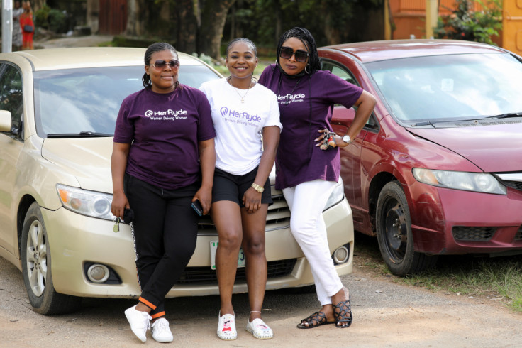 Members of HerRyde, a ride-hailing app with exclusively women drivers, pose in front of a car, in Abuja