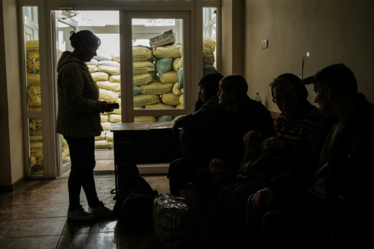 People wait to be evacuated  in Kozacha Lopan, one of the first towns to fall in this month's dramatic Ukrainian advance