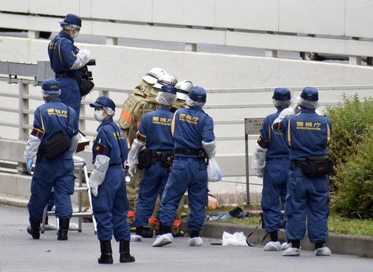 Police officers investigate at the site where a man who was protesting a state funeral for former Japanese Prime Minister Shinzo Abe set himself on fire