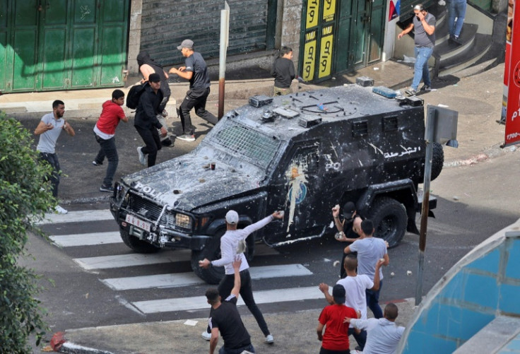 Youths hurl stones at a Palestinian Authority armoured truck amid anger at the security forces' arrest of two Hamas members in an operation seen as carried out at Israel's behest