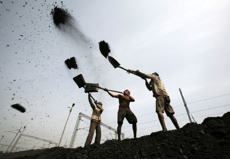 Workers load coal onto trucks on the outskirts of Jammu