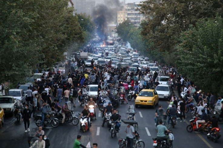 Demonstrators are seen taking to a street in the Iranian capital Tehran on September 21, 2022