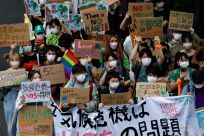 People raise placards as they take part in a global climate protest march, at Omotesando district in Tokyo