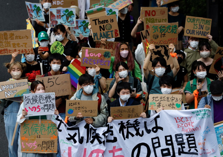 People raise placards as they take part in a global climate protest march, at Omotesando district in Tokyo