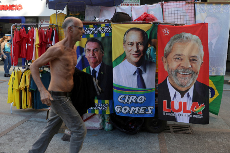 A man runs past banners with photos of presidential candidates in Rio de Janeiro