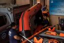 Members of the Disaster Risk Reduction and Management Office prepare rubber boats and life vests ahead of Super Typhoon Noru making landfall