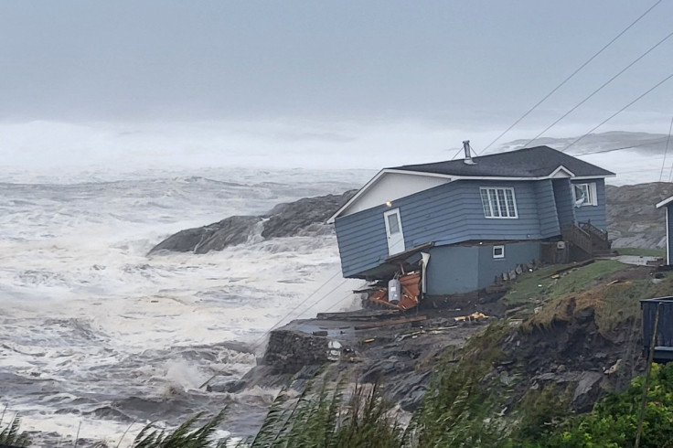 Waves roll in near a house built close to the shore as Hurricane Fiona passes Port aux Basques