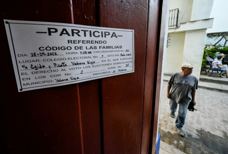 A man arrives at a polling station in Havana; the sign announces the referendum on a new Family Code for Cuba