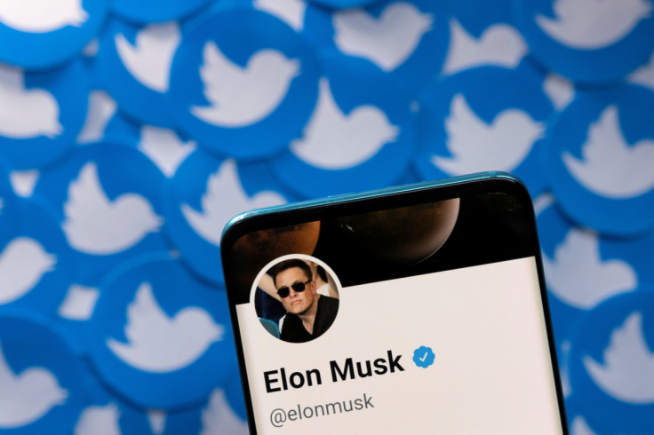 Illustration shows Elon Musk's Twitter profile on smartphone and printed Twitter logos