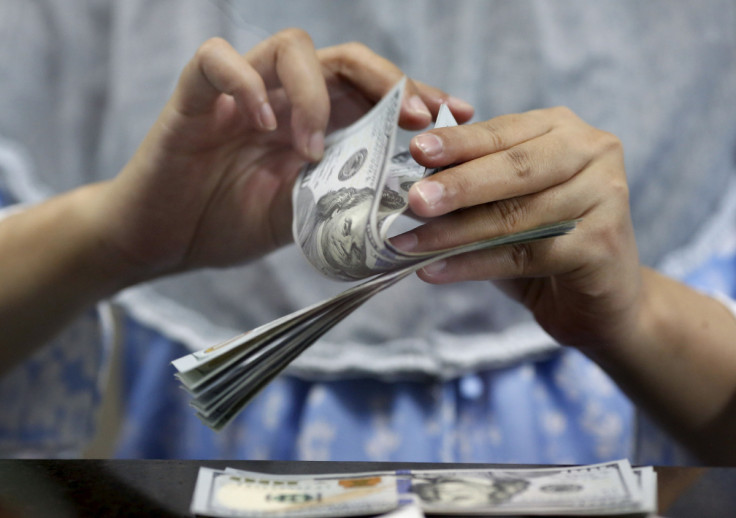 A teller counts U.S. dollars at a money changer in Jakarta, Indonesia