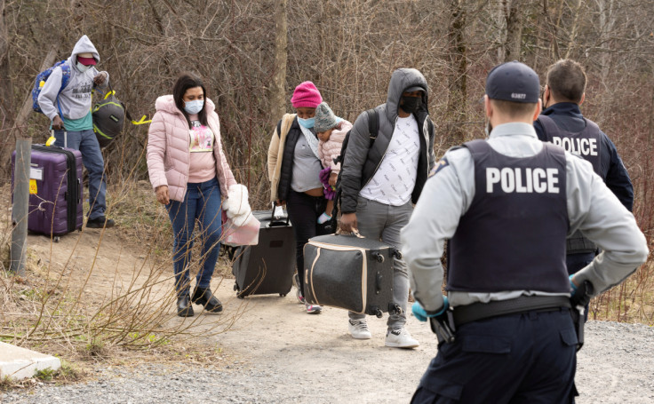 Asylum seekers cross into Canada near a checkpoint on Roxham Road