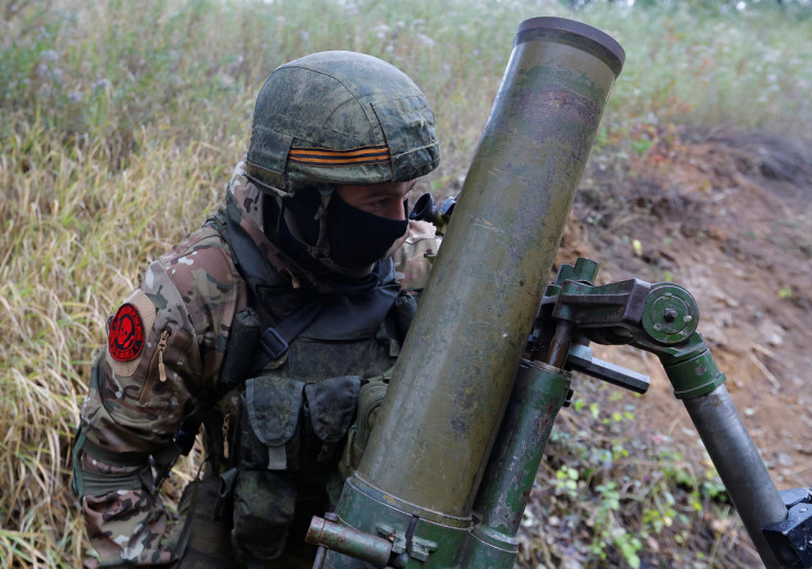 Service members of pro-Russian troops fire a mortar outside Donetsk