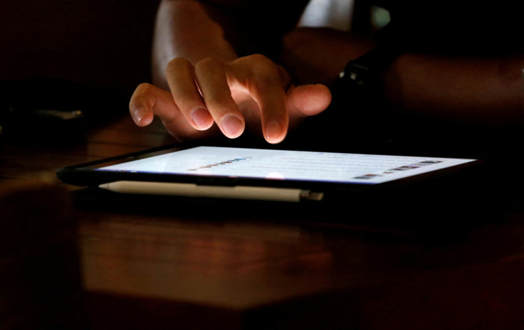 A man uses an iPad device in a coffee shop in Hanoi