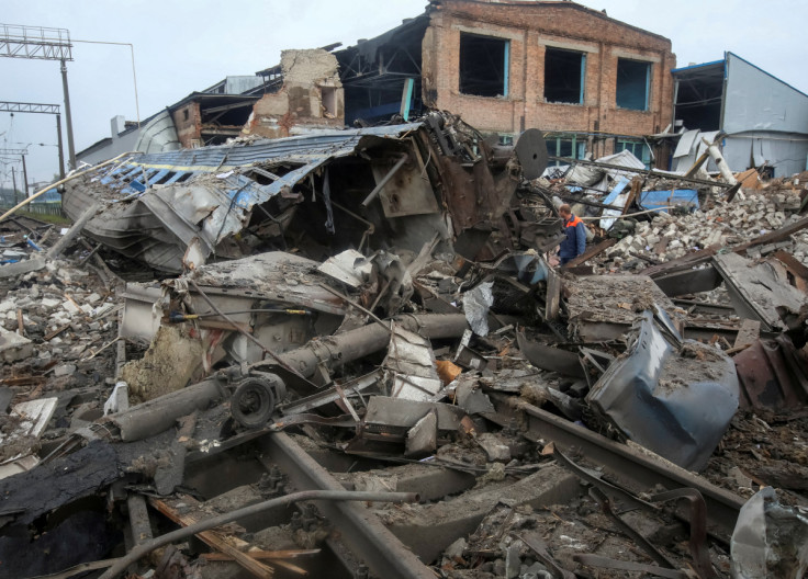 A worker is seen near destroyed by Russian military strike train cars at freight railway station in Kharkiv