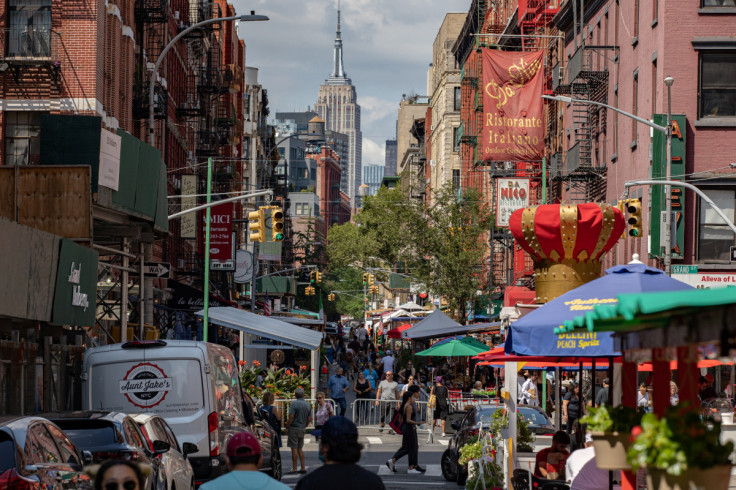 People walk down a street lined with outdoor seating for restaurants in the Little Italy neighborhood of Manhattan, in New York City