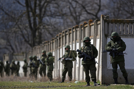 Russian military personnel surround a Ukrainian military 