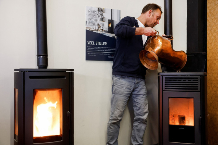 Pellet stove seller Wouter van Werven puts pellets into a pellet stove, in Wormer