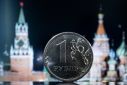 A Russian one rouble coin is pictured in front of a monitor showing the Kremlin's tower