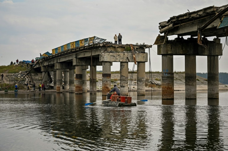 Local residents cross the Donets river next to a destroyed bridge