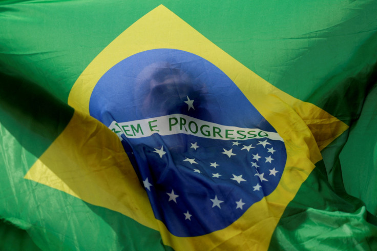 A man holds a Brazilian flag while taking part in a motorcade to show support for Brazilian President Jair Bolsonaro, in Brasilia