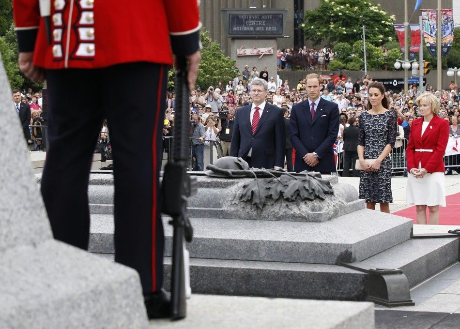  Canadas Prime Minister Harper and wife Laureen stand in silence alongside Britains Prince William and wife Catherine, Duchess of Cambridge at the National War Memorial in Ottawa