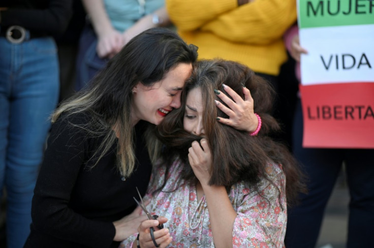 A protester cries as another cuts her hair during a demonstration in support of Kurdish woman Mahsa Amini on Saturday in Madrid