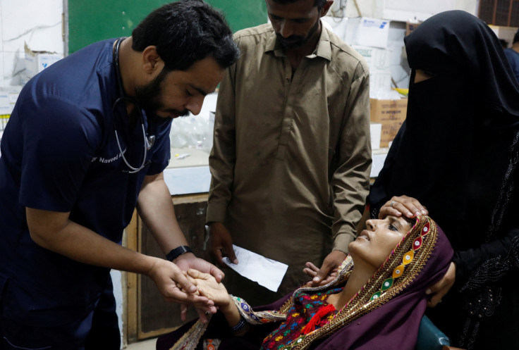 Woman suffering from malaria and fever receives medical assistance at Sayed Abdullah Shah Institute of Medical Sciences in Sehwan