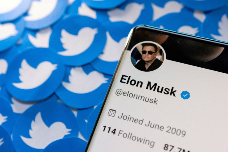 Illustration shows Elon Musk's Twitter profile on smartphone and printed Twitter logos