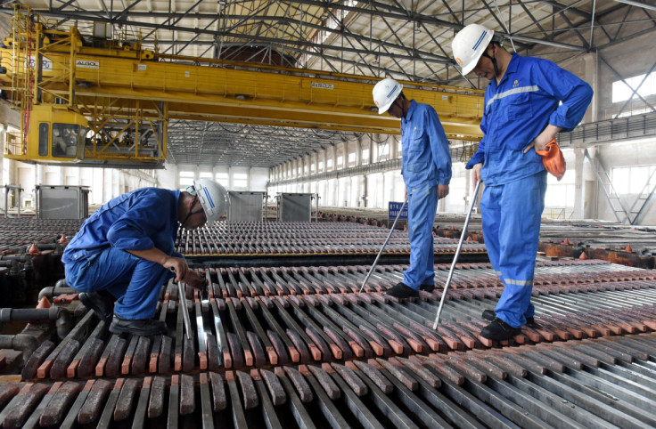 Workers inspect the production of copper cathodes at a Jinlong Copper plant in Tongling