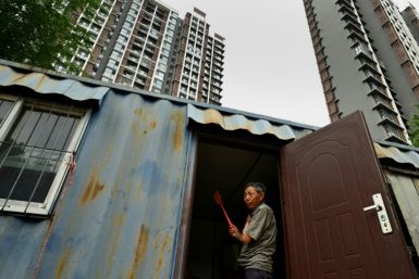 A migrant worker stands at the entrance to his living quarters in Beijing's middle-class neighbourhood of Shangdi