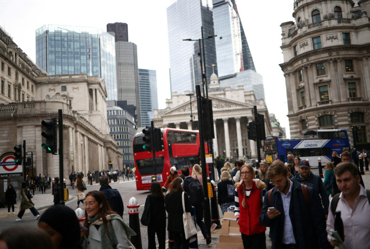People walk through the City of London financial district during rush hour in London