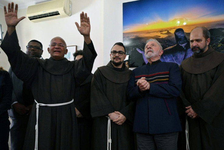 Fray Davi gives his blessing next to (L to R) Fray Gabriel, Brazilian former President (2003-2010) and candidate for the leftist Workers Party (PT) Luiz Inacio Lula da Silva, and Fray Paulo during a meeting to commemorate St. Francis of Assisi day, at the