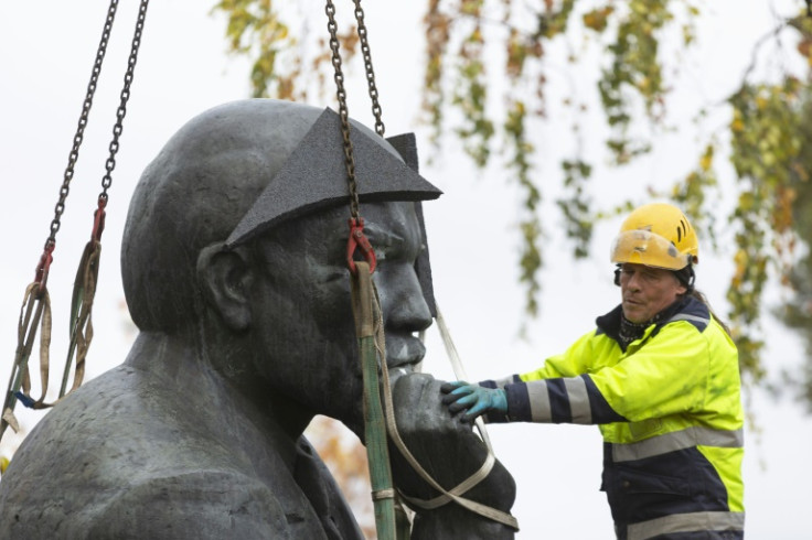 Some brought champagne to celebrate, while one man protested with a Soviet flag as the bronze bust of the leader was lifted off its pedestal