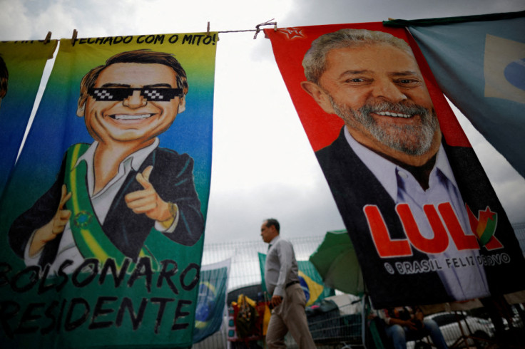 A man walks past presidential campaign materials depicting Brazil's former President Luiz Inacio Lula da Silva and and President Jair Bolsonaro in Brasilia