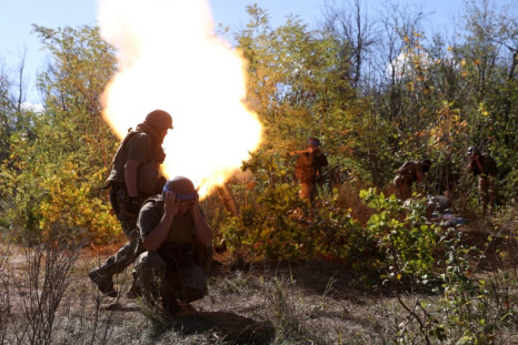 Ukrainian servicemen fire a mortar from their position on the front line with Russian troops in Donetsk