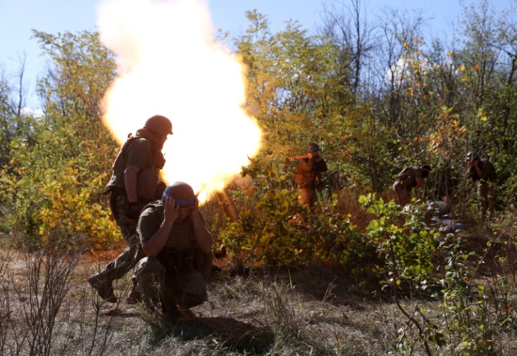 Ukrainian servicemen fire a mortar from their position on the front line with Russian troops in Donetsk