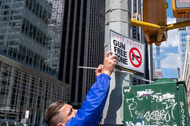 FILE PHOTO - New York City police officers instal signs that read "gun free zone" at Times Square as new gun laws are due to come into effect