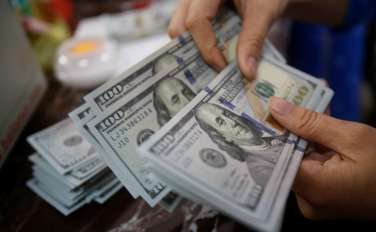 An employee of a bank counts US dollar notes at a branch in Hanoi