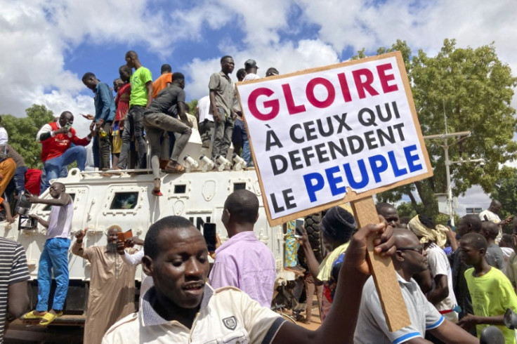 Protestors in the Burkina Faso Ouagadougou stand atop a UN armoured vehicle last weekend in support of the latest coup. The sign reads 'Glory to those who defend the people'
