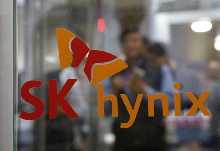 Employees walk past the logo of SK Hynix at its headquarters in Seongnam