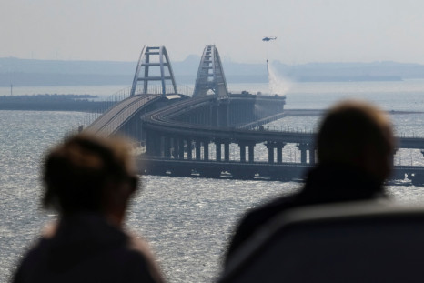 People watch fuel tanks ablaze on the Kerch bridge in the Kerch Strait