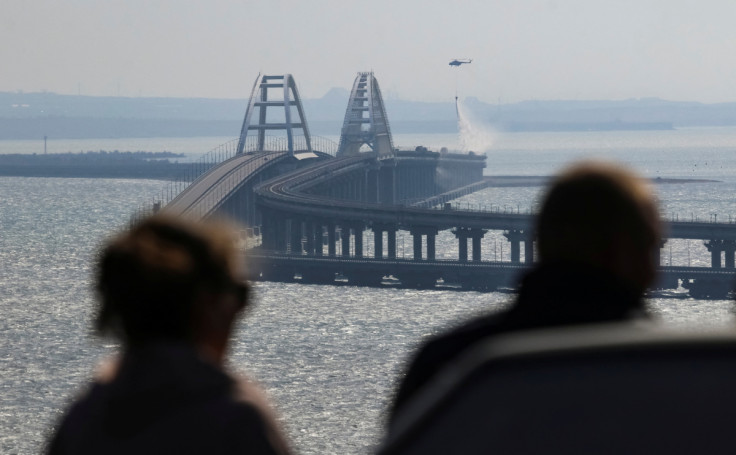 People watch fuel tanks ablaze on the Kerch bridge in the Kerch Strait